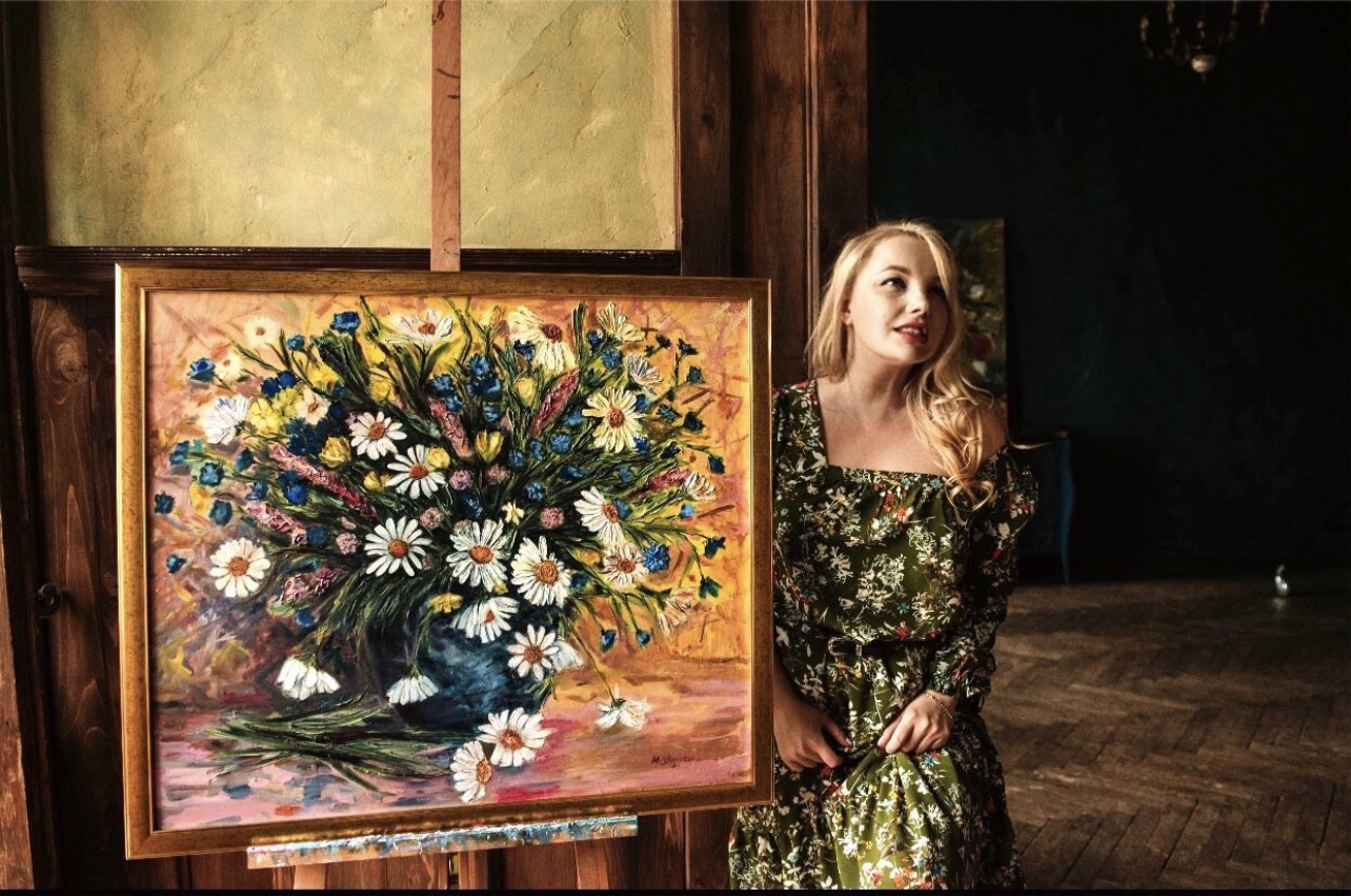 Ukrainian artist Marina Stognieva with her painting Wildflowers